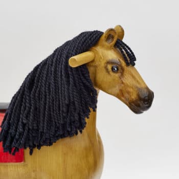 Detail on head of wooden rocking horse, tan colors